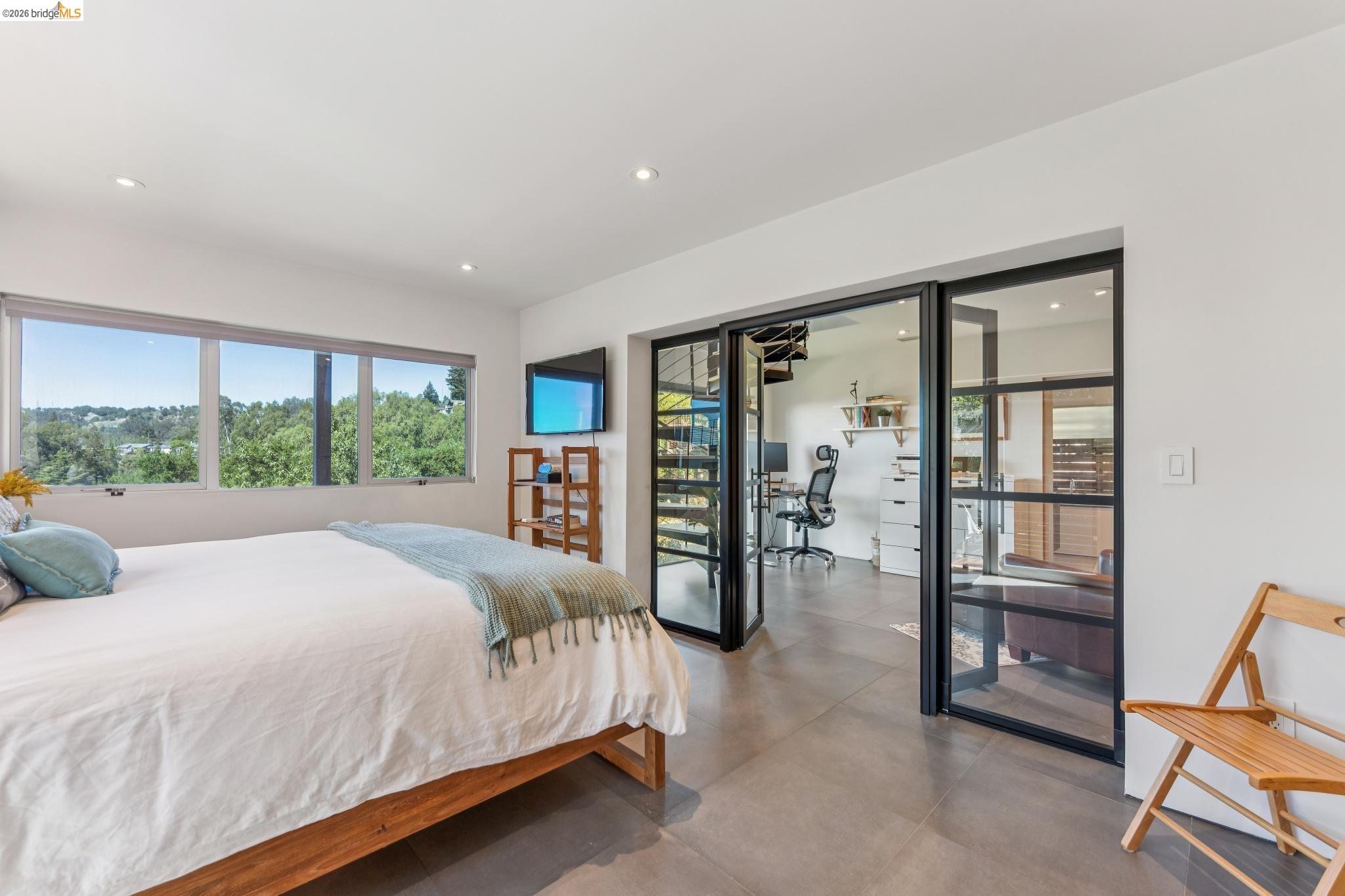 6733 Snake Road Oakland, CA 94611 - Photo 28 of 57 a bedroom with a large bed and a large window