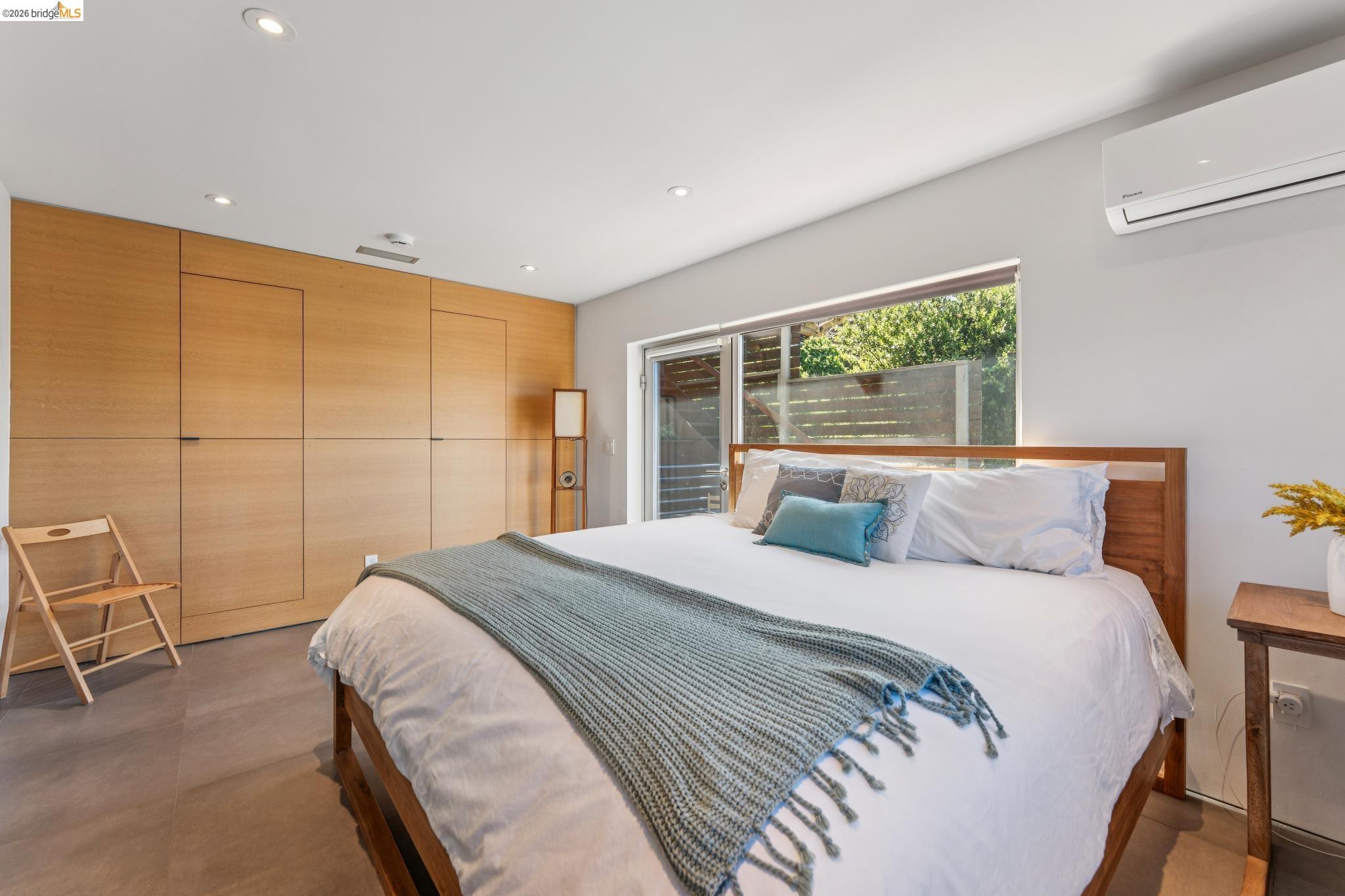 6733 Snake Road Oakland, CA 94611 - Photo 29 of 57 a bedroom with a large bed and a chair