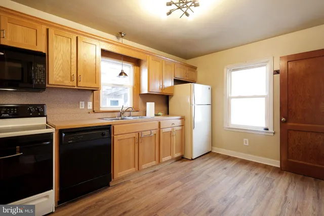 a kitchen with a white cabinets and wooden floor