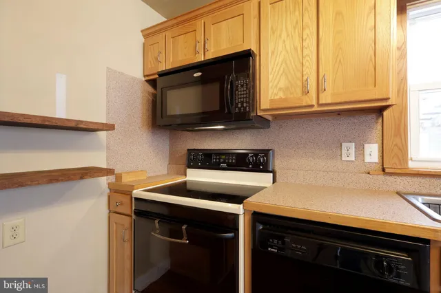 a kitchen with stainless steel appliances a stove microwave and sink