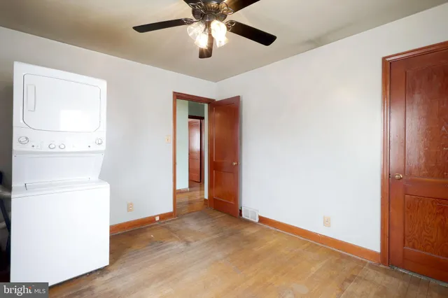 an empty room with closet and a chandelier fan