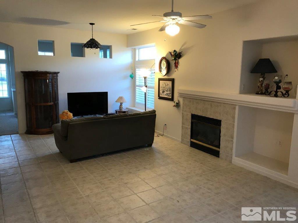 1840 Montelena Court Reno, NV 89521 - Photo 3 of 18 a living room with furniture a fireplace and a flat screen tv