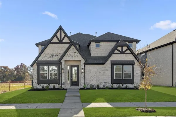 a front view of a house with a garden and yard