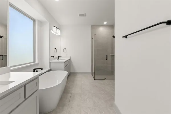 a bathroom with a sink a large mirror and a bathtub