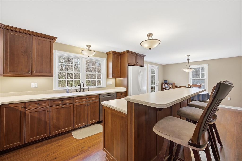 200 Nashua Road Groton, MA 01450 - Photo 12 of 41 a dining hall with stainless steel appliances granite countertop a dining table chairs and a refrigerator