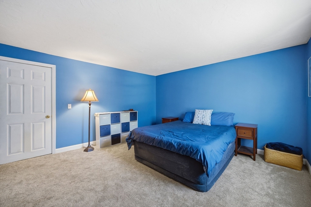 200 Nashua Road Groton, MA 01450 - Photo 27 of 41 a bedroom with a bed and a lamp with wooden floor
