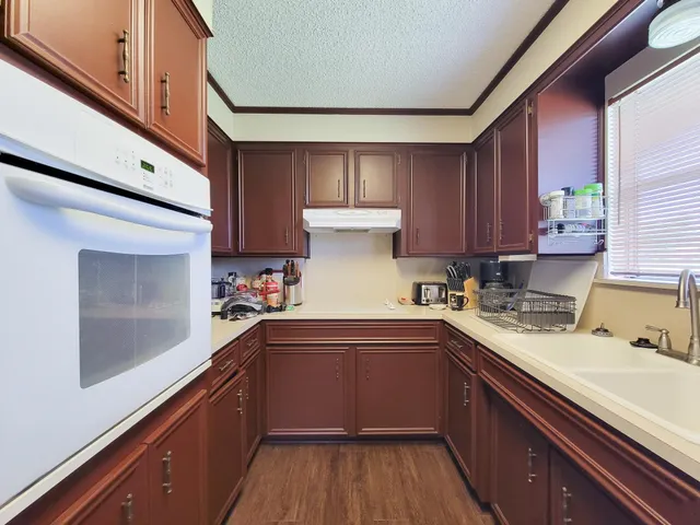 a kitchen with granite countertop a sink stainless steel appliances and cabinets