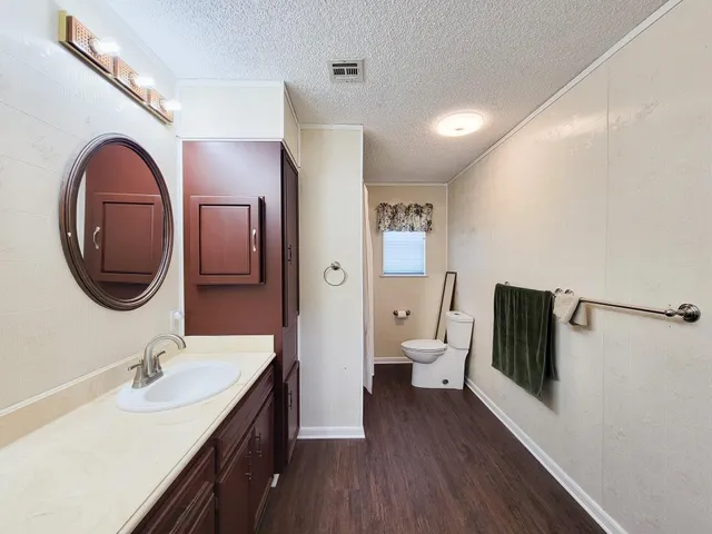 a bathroom with a toilet a sink and mirror