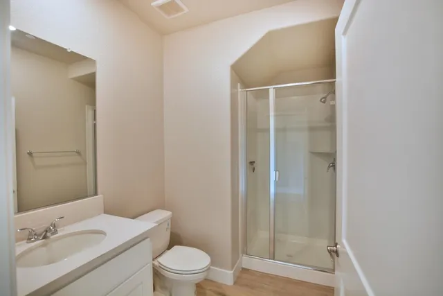 a bathroom with a granite countertop sink toilet a mirror and shower