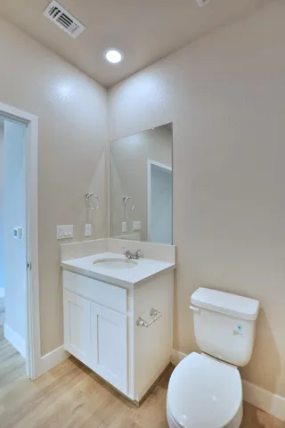 a bathroom with a toilet a sink and mirror