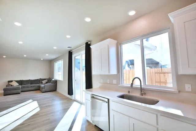 a large kitchen with stainless steel appliances a large window in it