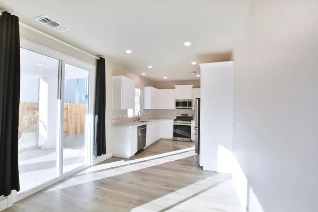 a view of a kitchen with a refrigerator and a sink