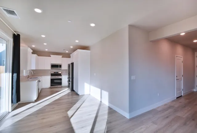 a view of a kitchen with a sink and a refrigerator
