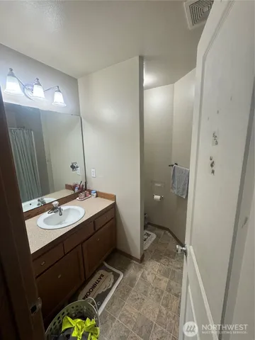 a bathroom with a sink and mirror with toilet