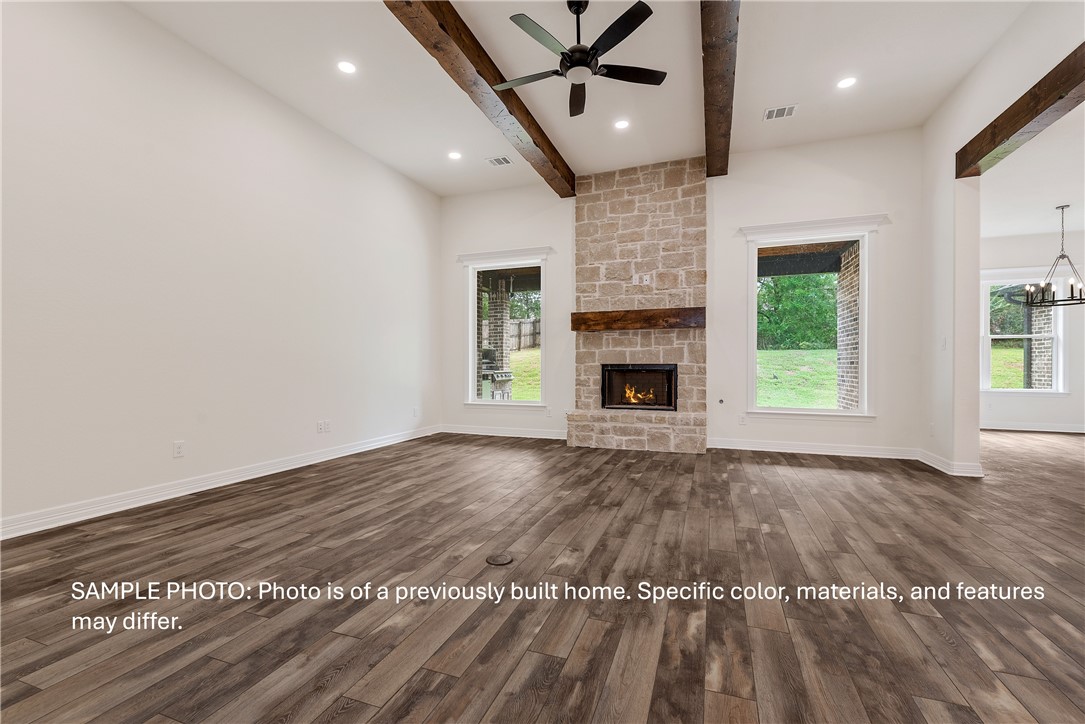7020 Skipping Rock Path Bryan, TX 77808 - Photo 4 of 19 an empty room with wooden floor fireplace and windows