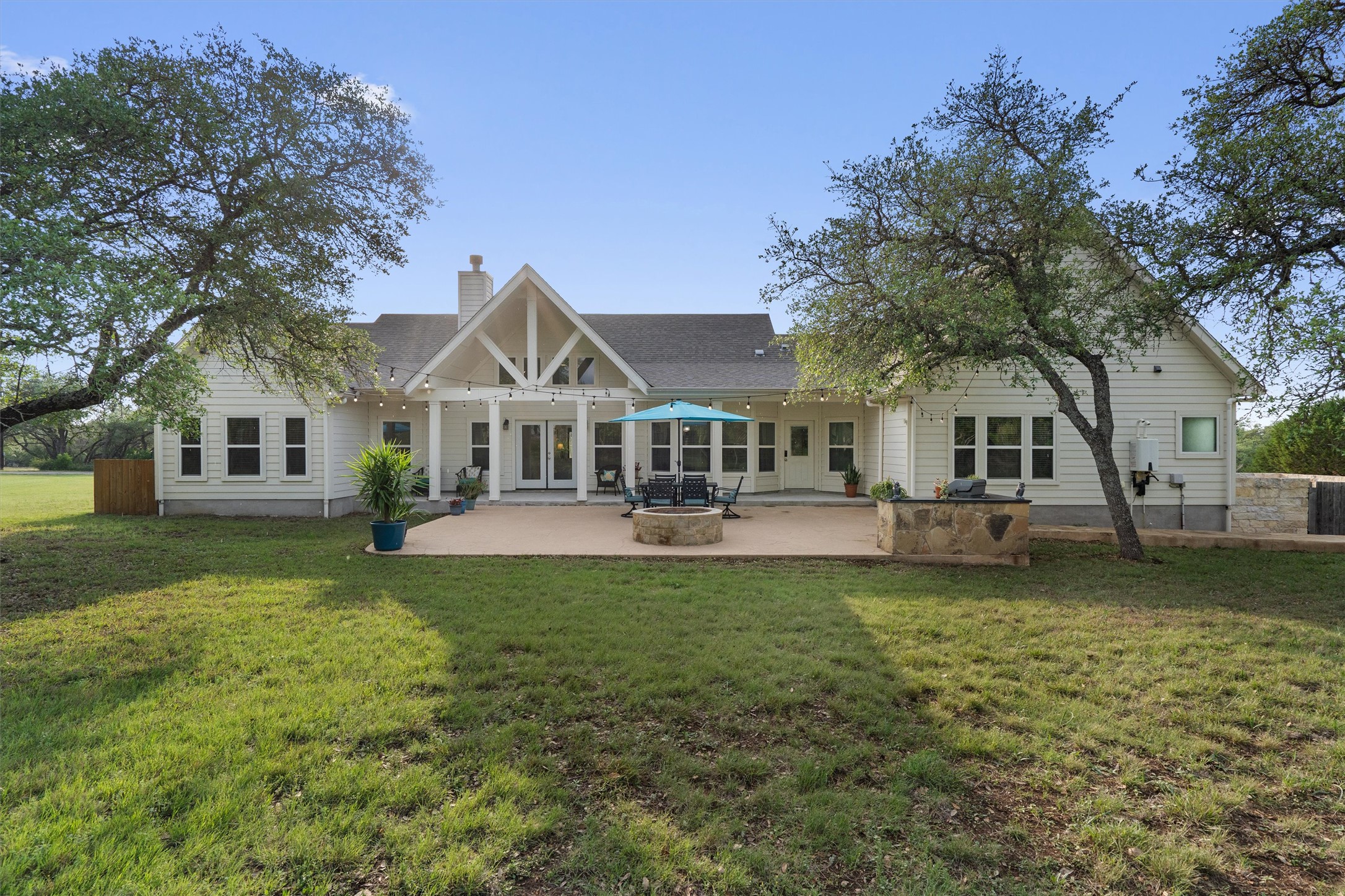 13105 Rooster Springs Road Austin, TX 78737 - Photo 26 of 38 The property features a spacious backyard with a large lawn and mature trees