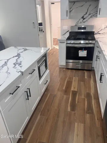 a kitchen with granite countertop white cabinets and white appliances