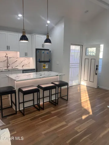 a kitchen with a table chairs refrigerator and microwave