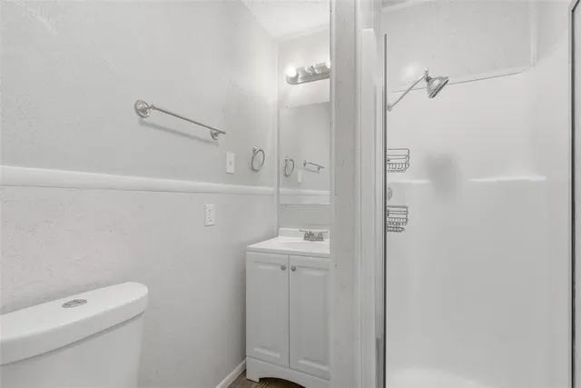 a bathroom with a sink a toilet and shower