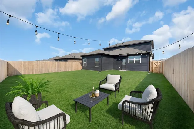 a view of a chair and table in back yard of the house