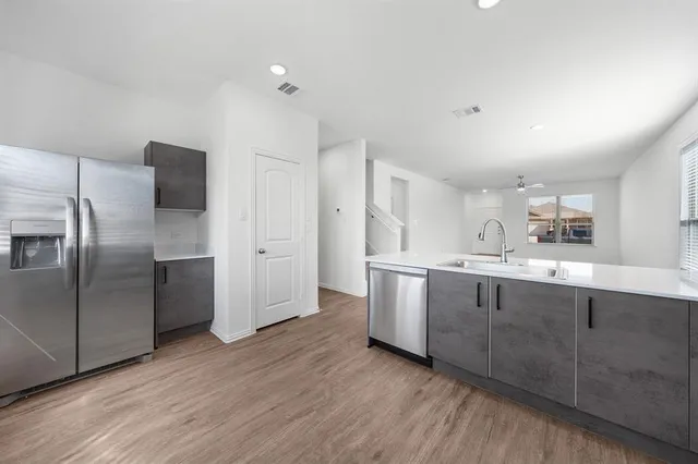 a kitchen with granite countertop a refrigerator and a sink