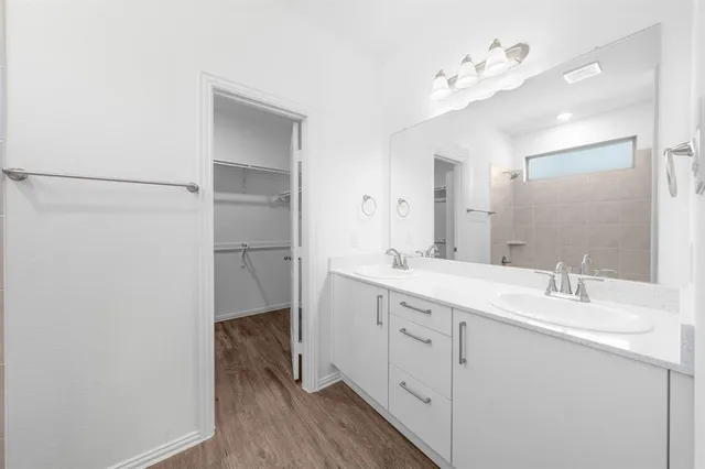 a bathroom with a double vanity sink mirror and shower