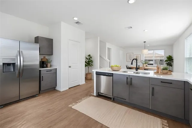 a kitchen with granite countertop a refrigerator and a sink