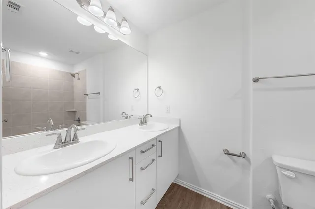 a bathroom with a sink a toilet and a mirror