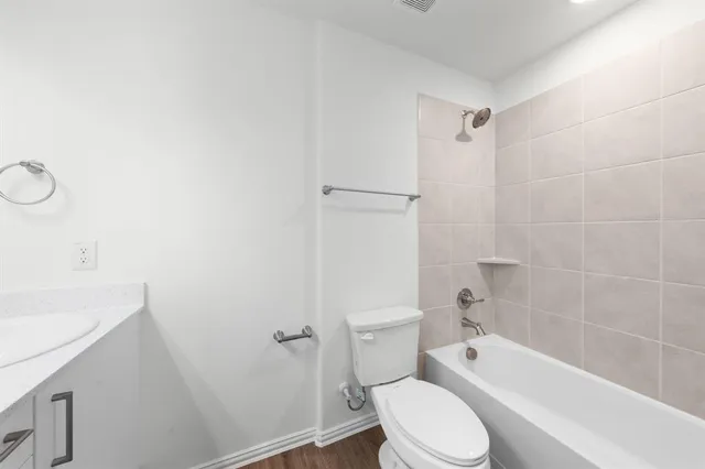 a white toilet sitting next to a bath tub