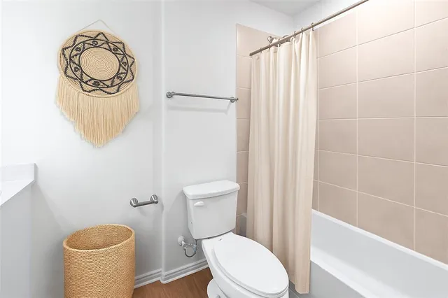 a white toilet sitting next to a bathroom sink and a shower