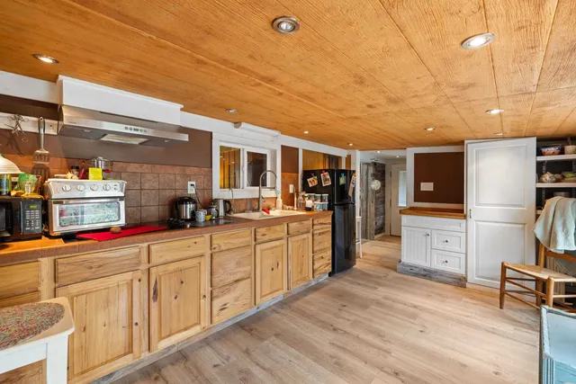 a large kitchen with kitchen island a sink a stove and wooden cabinets