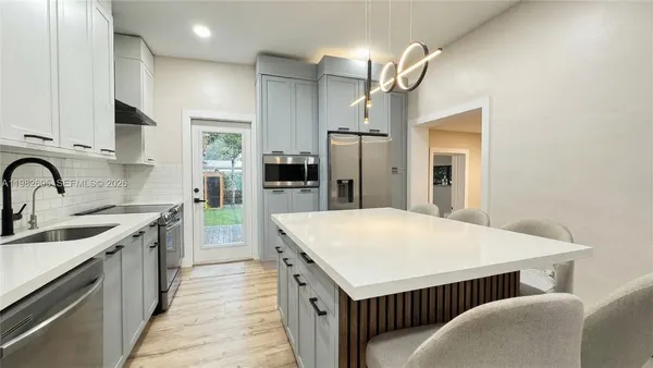 a kitchen with stainless steel appliances a refrigerator sink and cabinets