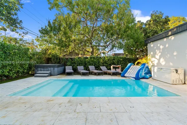 a living room with patio furniture and a wooden floor