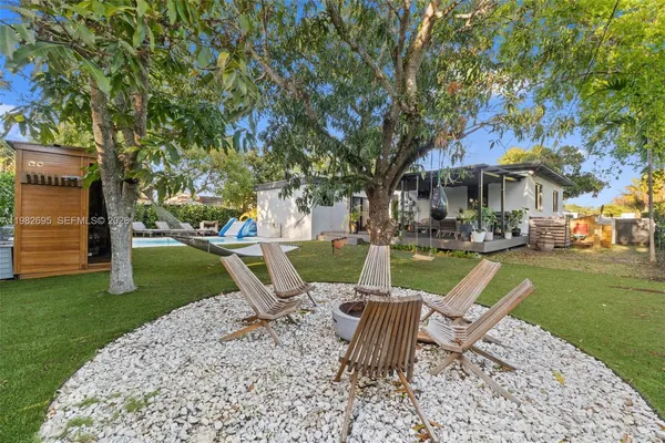 an aerial view of residential houses with outdoor space and trees
