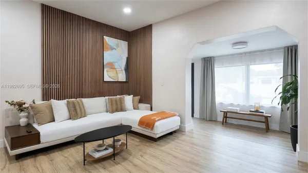 a living room with furniture and wooden floor