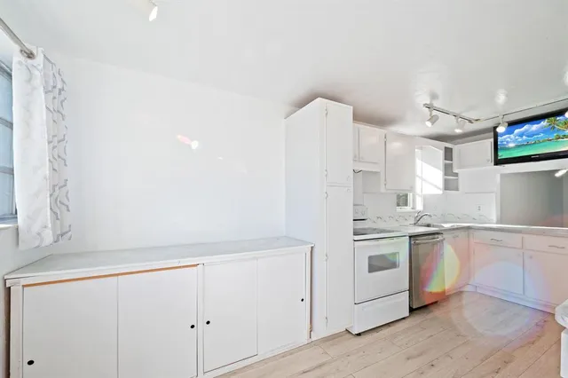 a kitchen with a refrigerator sink and cabinets