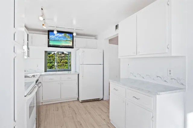 a kitchen with granite countertop a sink stainless steel appliances and cabinets