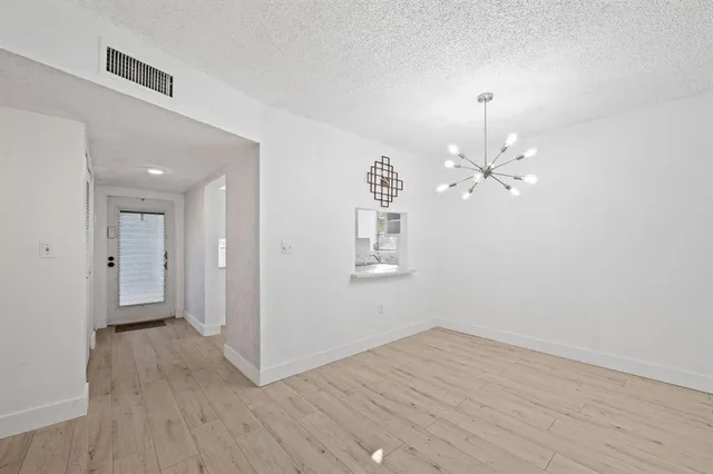 a view of a room with wooden floor and ceiling fan
