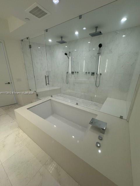 18555 Collins Avenue, Unit 2905 Sunny Isles Beach, FL 33160 - Photo 29 of 40 a view of a bathroom with a tub a sink a mirror and a shower