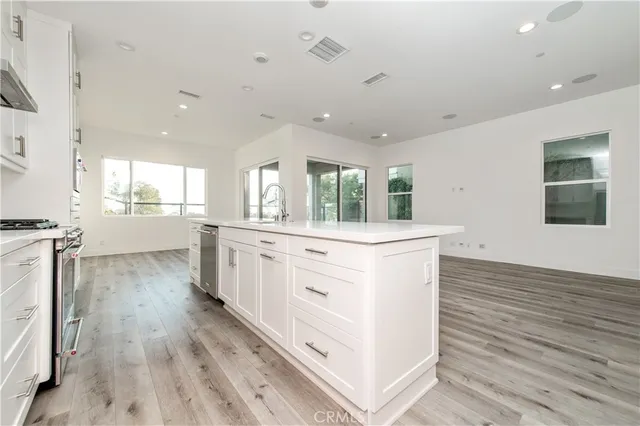 a kitchen with white cabinets and sink