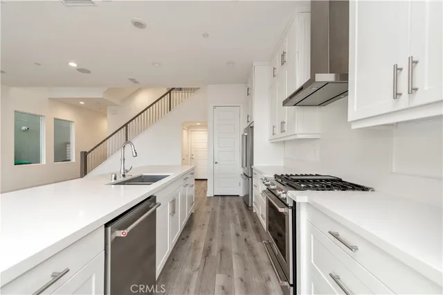 a kitchen with stainless steel appliances a sink stove and cabinets