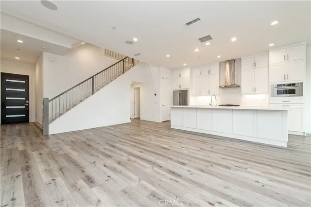 a view of kitchen with kitchen island sink stainless steel appliances and cabinets