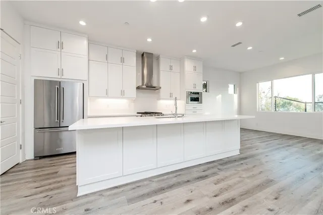 a kitchen with kitchen island white cabinets and refrigerator
