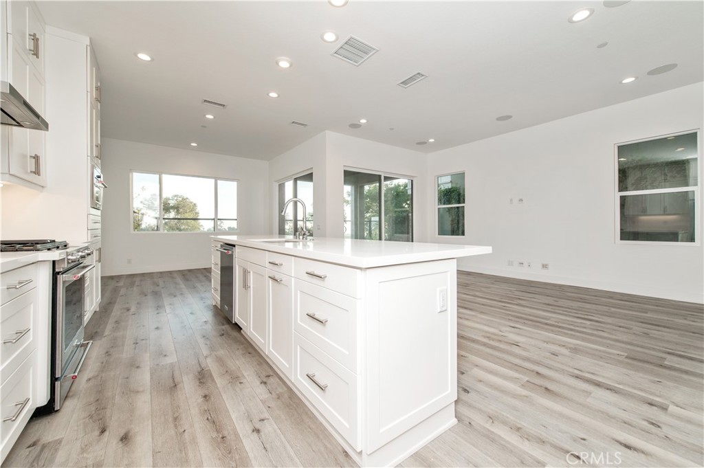 26380 Paseo Sillin San Juan Capistrano, CA 92675 - Photo 24 of 49 a large kitchen with stainless steel appliances kitchen island a large counter top a sink a stove and a refrigerator