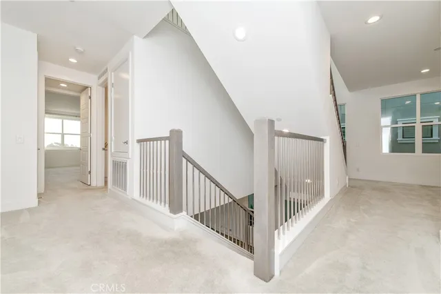 a view of a hallway with white walls and windows
