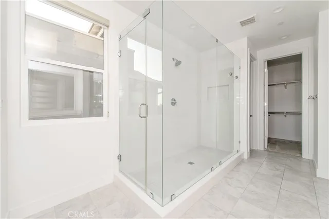 a bathroom with a shower and a glass door