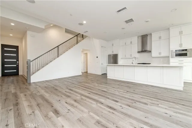 a view of kitchen with wooden floor and electronic appliances