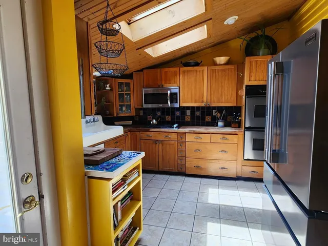 a kitchen with stainless steel appliances a stove a sink and a refrigerator