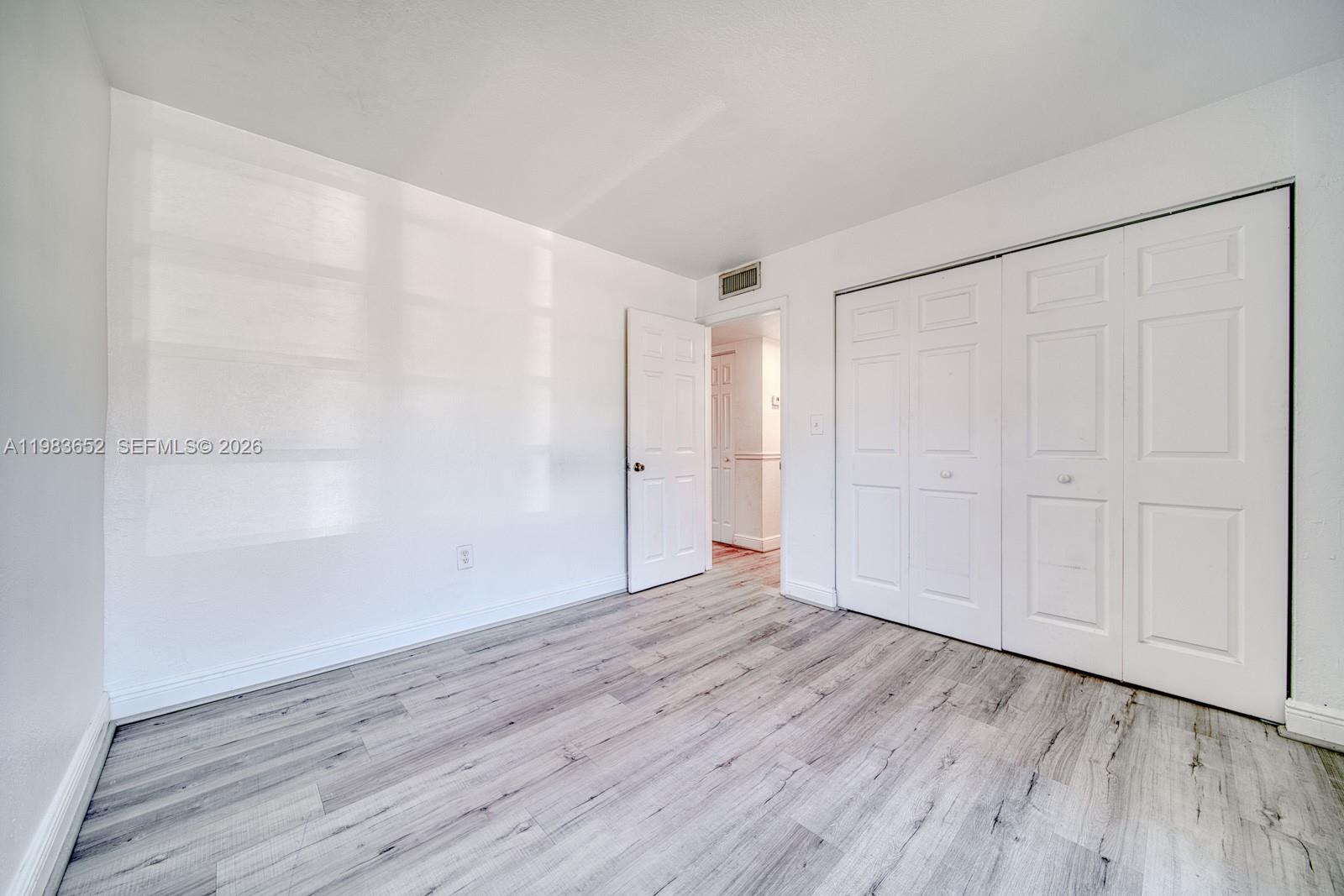 9459 Southwest 76th Street, Unit R5 Miami, FL 33173 - Photo 16 of 33 a view of an empty room with wooden floor