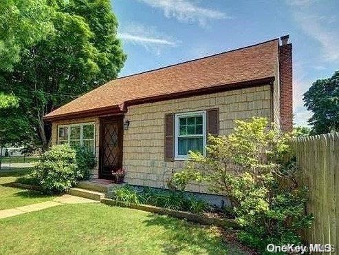 a view of a house with brick walls and a yard with plants